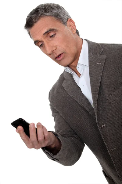 Surprised man looking at telephone — Stock Photo, Image