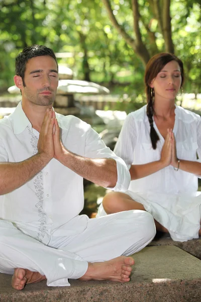 Paar mediteren in stenen tuin — Stockfoto