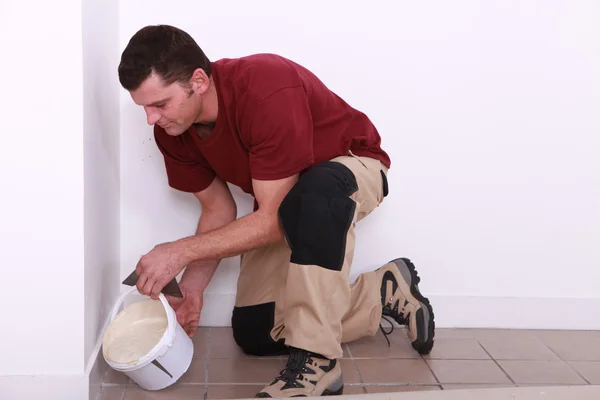 Człowiek wylewanie klej do płytek ceramicznych na starej podłodze — Zdjęcie stockowe