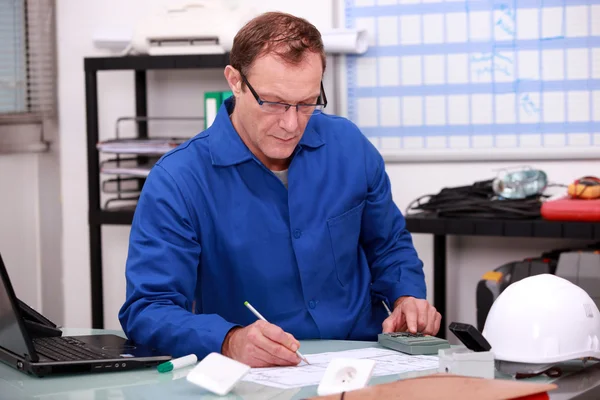 Bouwer bezig met papierwerk in een kantoor — Stockfoto