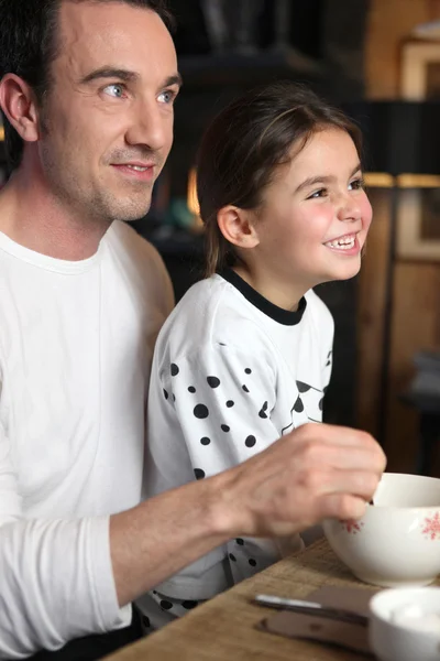 Far och dotter skrattar åt frukost — Stockfoto
