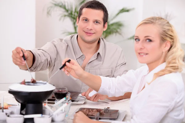 Pareja disfrutando de una fondue de chocolate — Foto de Stock