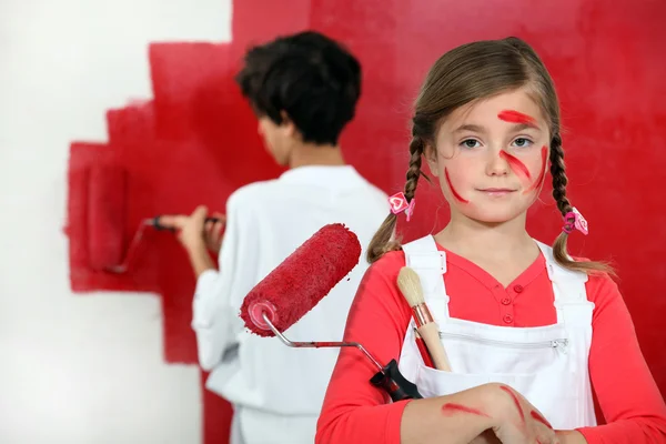 Crianças pintando uma parede vermelha — Fotografia de Stock