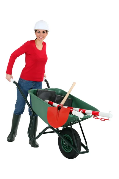 Craftswoman transporting instruments with a wheelbarrow — Stock Photo, Image