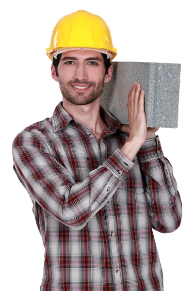 Costruttore con un blocco di cemento — Foto Stock