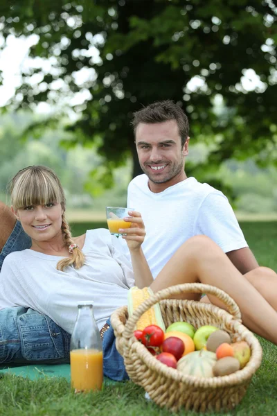 Couple avec panier de fruits dans le champ — Photo