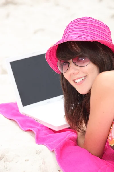 Mladá žena na pláži s notebookem — Stock fotografie