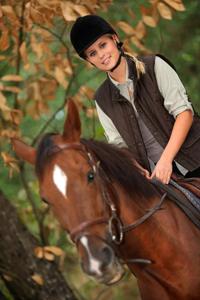 年轻的姑娘骑马穿过森林 — 图库照片