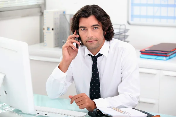 Affärsman i telefon vid sitt skrivbord — Stockfoto