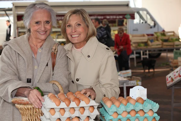 Moeder en dochter kopen eieren op een markt — Stockfoto
