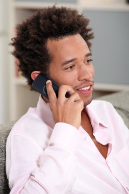 Man at home speaking on telephone clipart