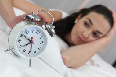 A woman stopping an alarm clock clipart