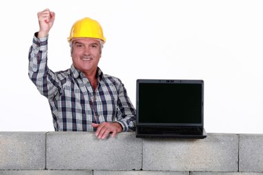 A mature mason with a laptop. clipart