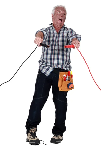Hombre recibiendo una descarga eléctrica de los cables de salto — Foto de Stock