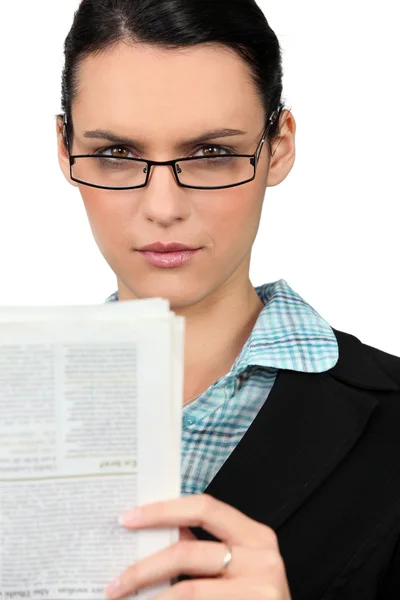 Женщина в очках читает газету — стоковое фото