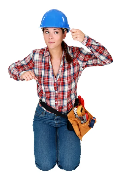 Young woman laborer gesturing, kneeling on white background — Stock Photo, Image