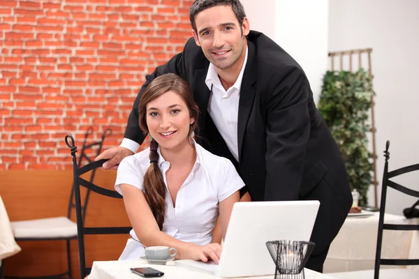Paar in einem Restaurant arbeitet an einem Laptop — Stockfoto