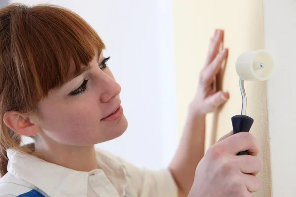 Woman carefully painting wall with roller — Stock Photo, Image