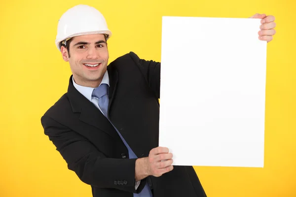 Empresário de construção segurando um cartaz em branco — Fotografia de Stock