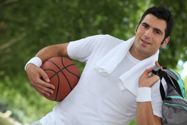 Schuin schot van man met basketbal en plunjezak — Stockfoto