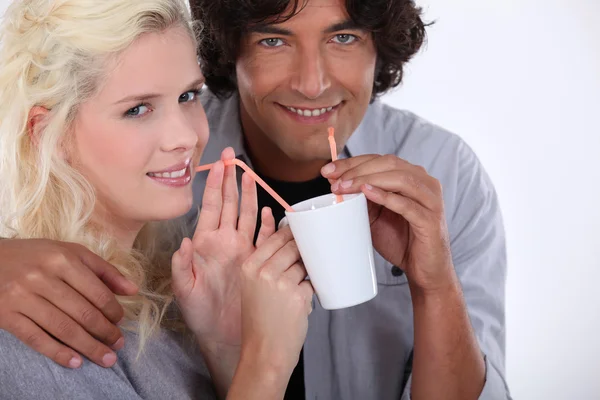 Paar trinkt aus derselben Tasse — Stockfoto