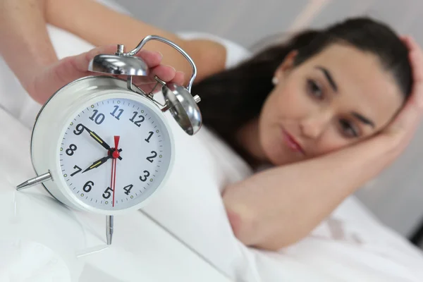 A woman stopping an alarm clock — Stock Photo, Image