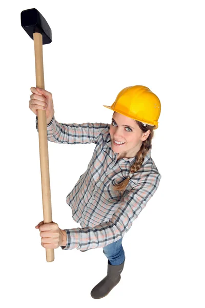 En kvinnlig byggnadsarbetare som innehar en slägga. — Stockfoto