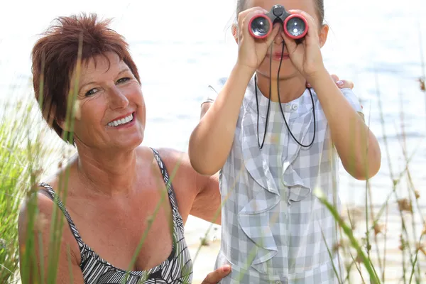 Little girl looking through binoculars — Stock Photo, Image