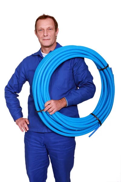 Rörmokaren med en rulle av blå rör — Stockfoto