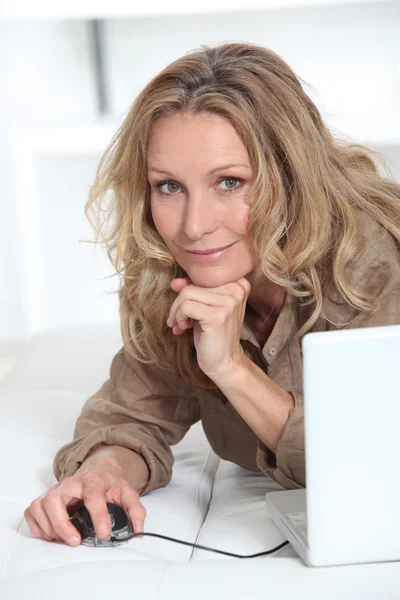 Sorrindo mulher relaxada com computador portátil — Fotografia de Stock