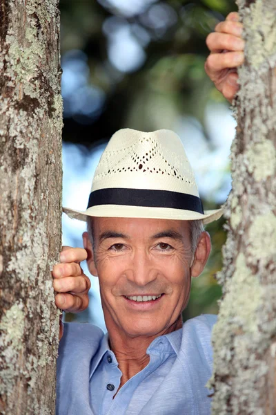 Senior man between two trees — Stock Photo, Image