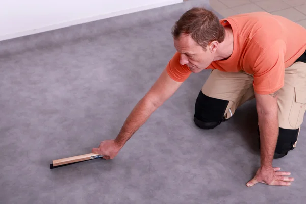 Mann renoviert den Fußboden — Stockfoto