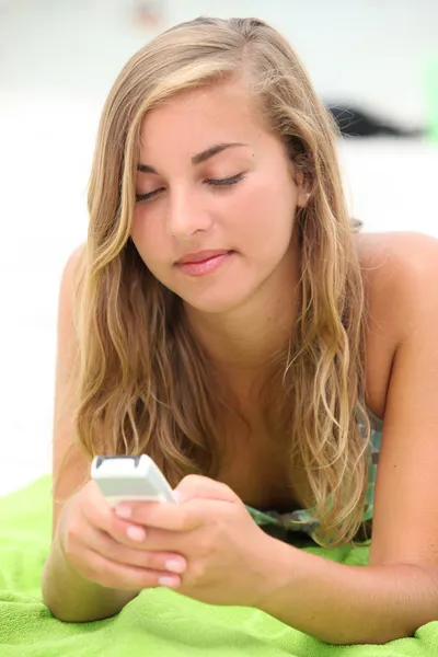 Adolescente menina mensagens de texto na praia — Fotografia de Stock