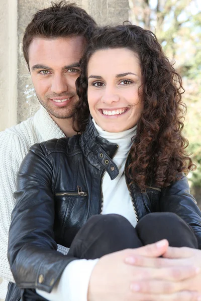 Mladý pár, seděl u zdi — Stock fotografie