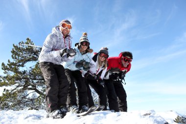 Four friends skiing together on holiday clipart