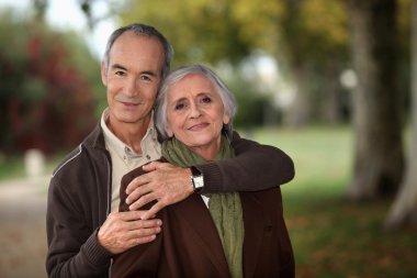 Old couple walking through park clipart