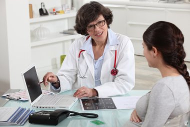 Doctor discussing a patient's results with her clipart