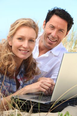 Couple smiling on laptop. clipart