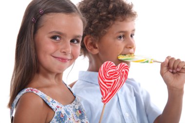 Two skittish kids with lollypops clipart