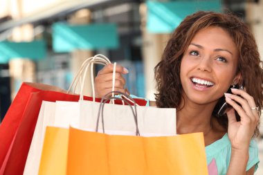 Woman shopping and talking on the phone clipart