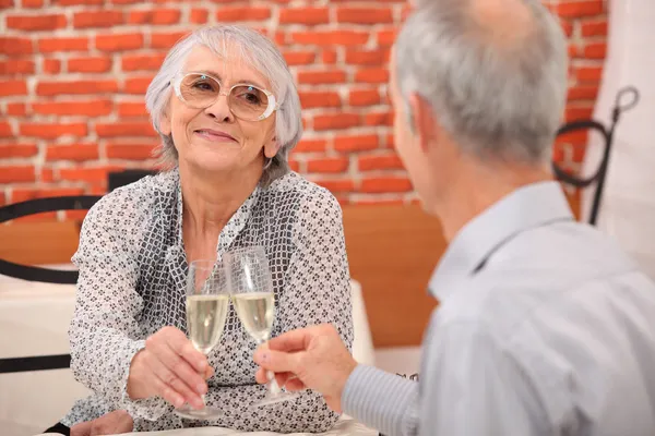 Älteres Paar prostet sich im Restaurant zu — Stockfoto