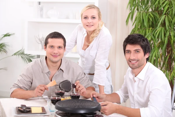 Freunde essen Raclette zum Abendessen — Stockfoto