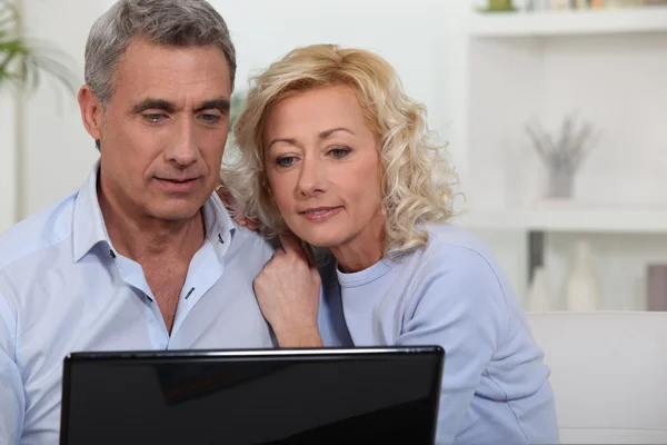 Couple looking at photos on their laptop — Stock Photo, Image