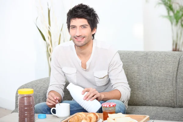 Człowiek o śniadanie na kanapie — Zdjęcie stockowe