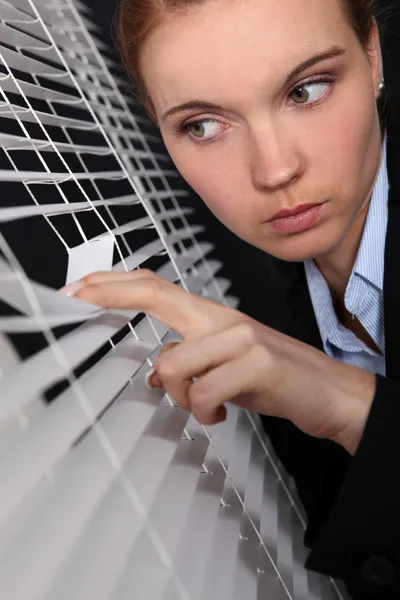 Mujer de negocios mirando a través de las persianas —  Fotos de Stock