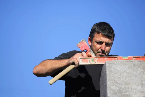 Handelaar met behulp van een bijl en een waterpas — Stockfoto