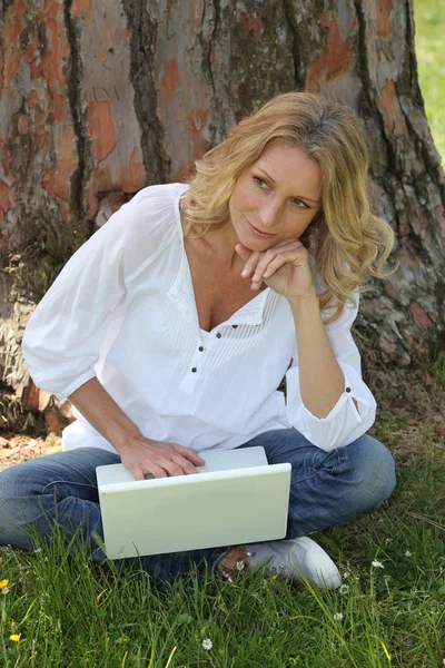 Frau benutzt Laptop im Park — Stockfoto