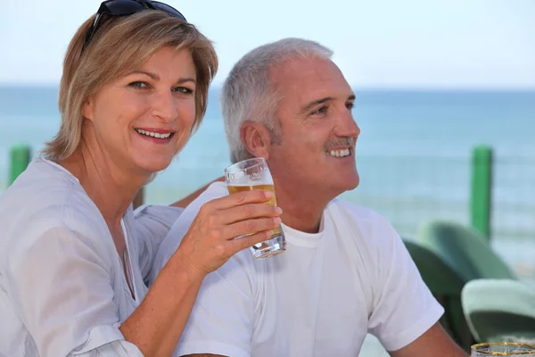 Casal beber cerveja no terraço da praia — Fotografia de Stock