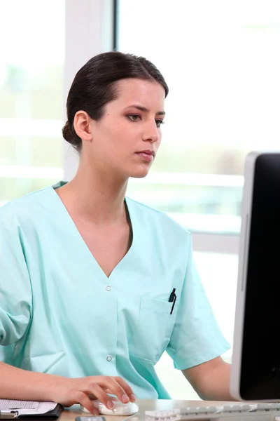 Verpleegkundige zit op een computer — Stockfoto