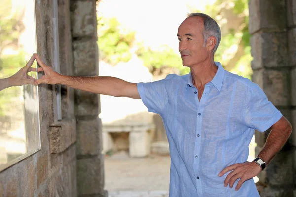 Senior tourist in an old stone building — Stock Photo, Image